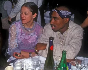 Madonna e Tupac Shakur juntos à mesa, representando um affair secreto e improvável de celebridades.